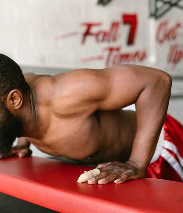 Man performing a controlled bodyweight exercise in a minimalist gym.